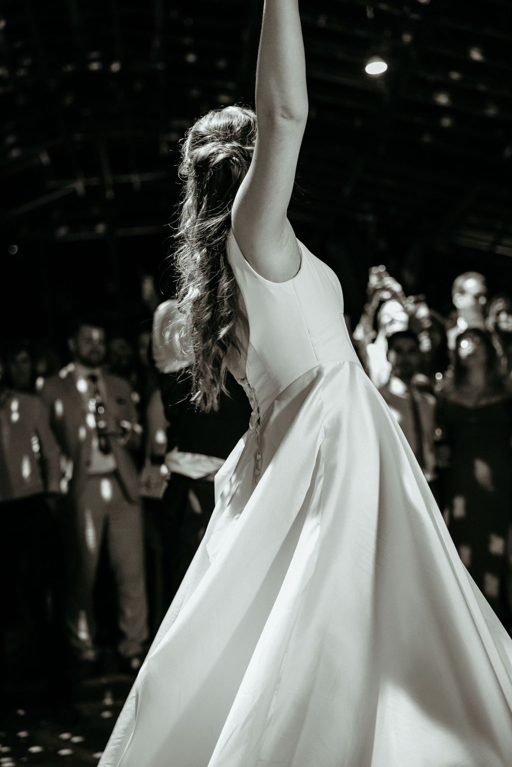Dramatic black and white photo of twirling wedding dress during dance.