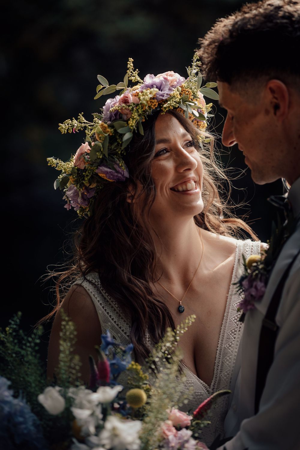 Intimate wedding moment with floral crown and natural lighting in garden setting.