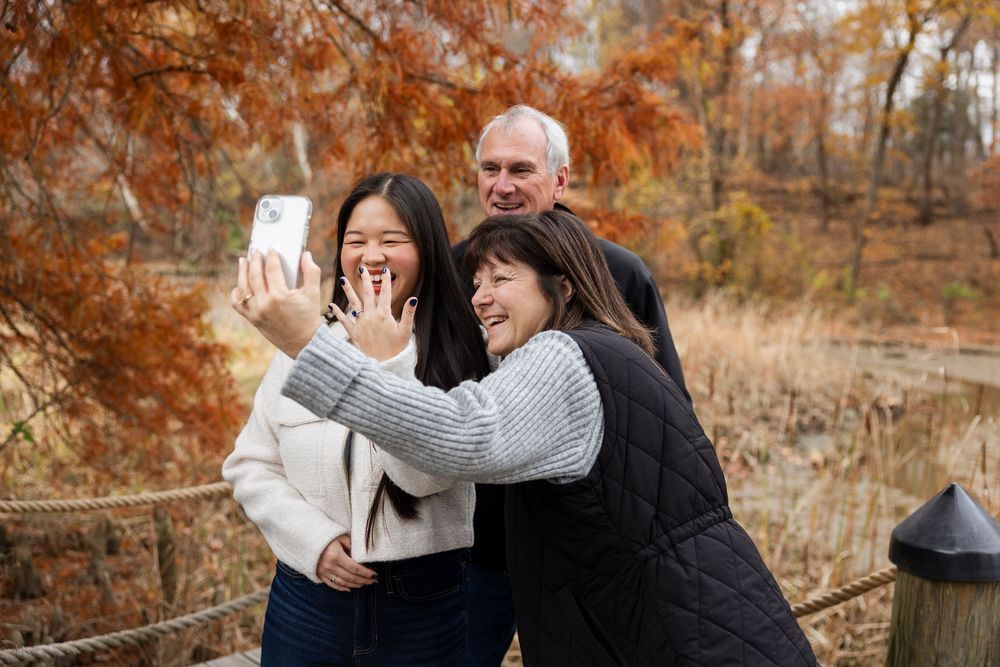 A couple shares joyful moments together in a beautiful autumn forest setting with golden leaves and warm sunlight.