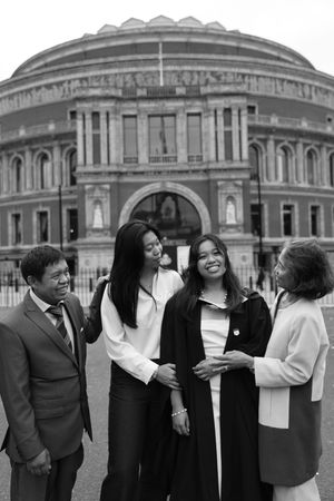 photo of a family smiling at a graduate in black and white.