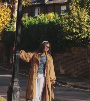 photograph of a woman holding a lamppost as she swings