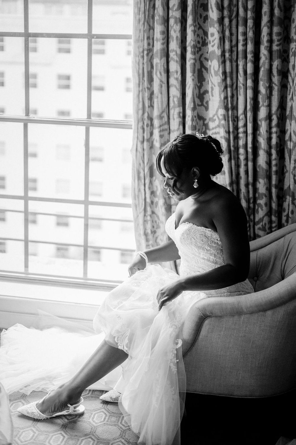 Black and white artistic photo series showing a woman in a wedding dress reclining on a chair by a window.