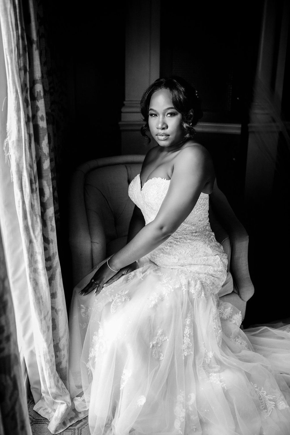 Artistic black and white portrait of someone in a flowing wedding gown.