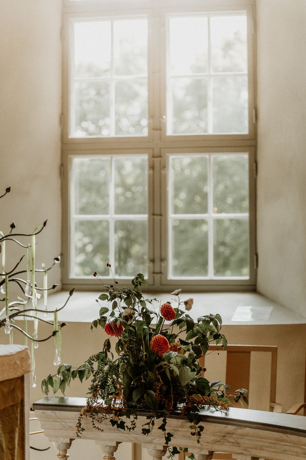 Blommor och sol genom fönster på Sandseryds kyrka.