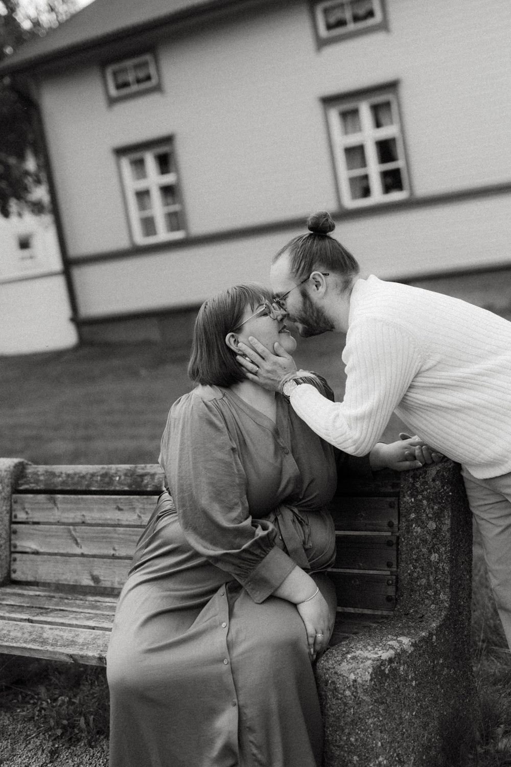 A romantic black and white photo sequence shows a couple sharing tender moments while sitting on a bench.