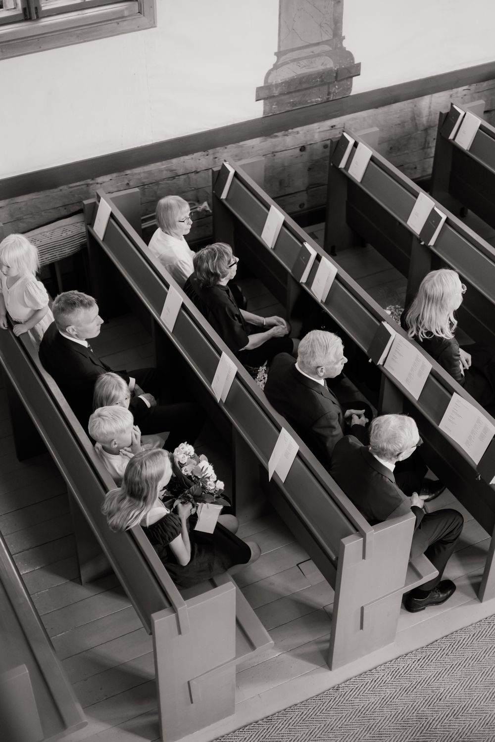 Congregation members seated in wooden church pews during a religious service.