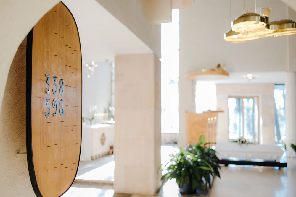 A series of six connected images showing a modern white kitchen interior with brown cork boards and pendant lighting.