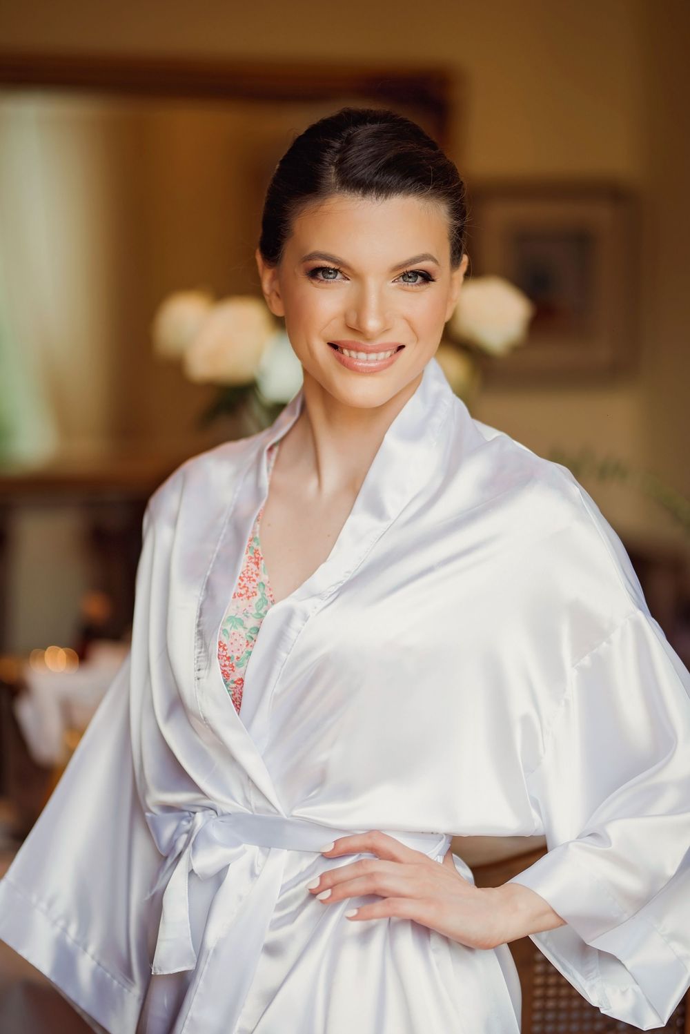 Radiant portrait of woman in luxurious white silk robe with classic wedding day styling.