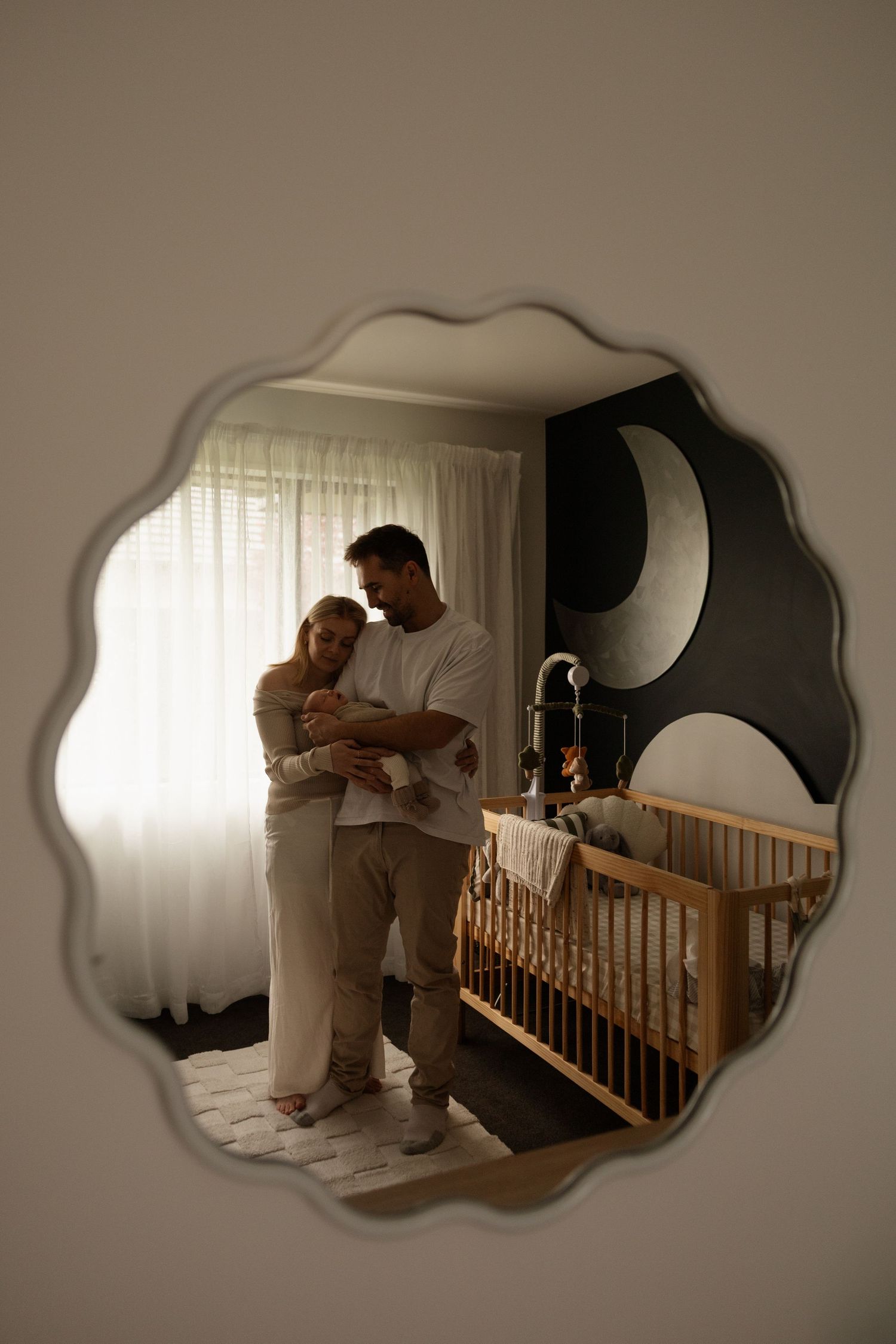 In home newborn session in Christchurch, cuddled up with mum and dad in babys room.