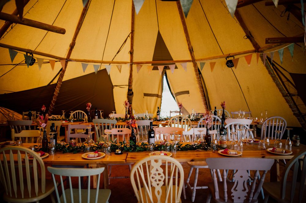 Wedding reception space under a tipi tent with string lights and white chairs. Worcestershire Wedding photographer.