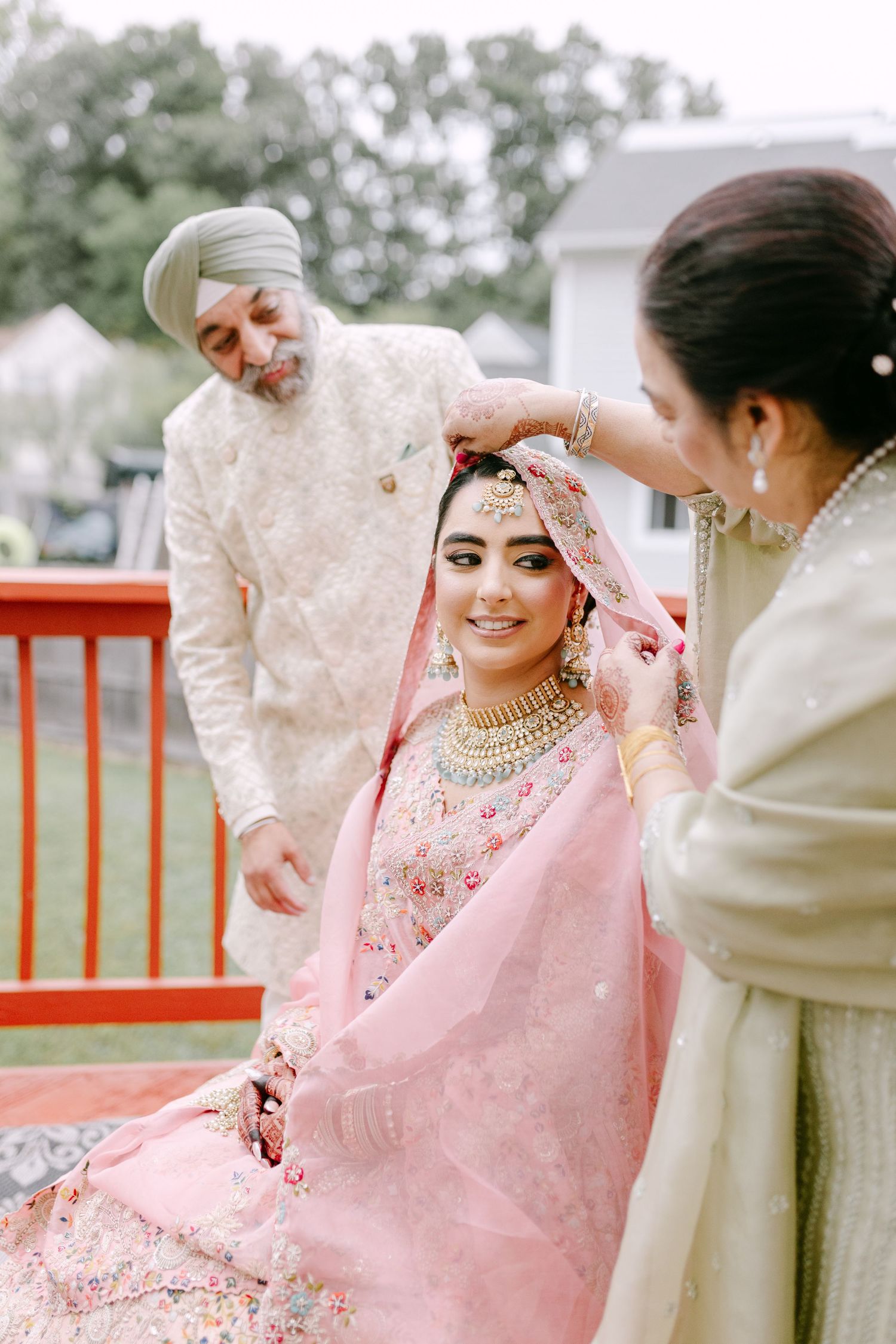 Traditional Sikh wedding preparation ceremony with pink attired bride.
