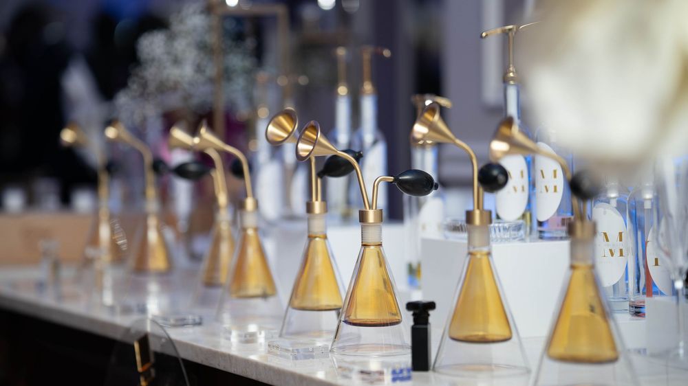 Laboratory glassware and test tubes filled with yellow liquid solutions arranged in a row for scientific research.
