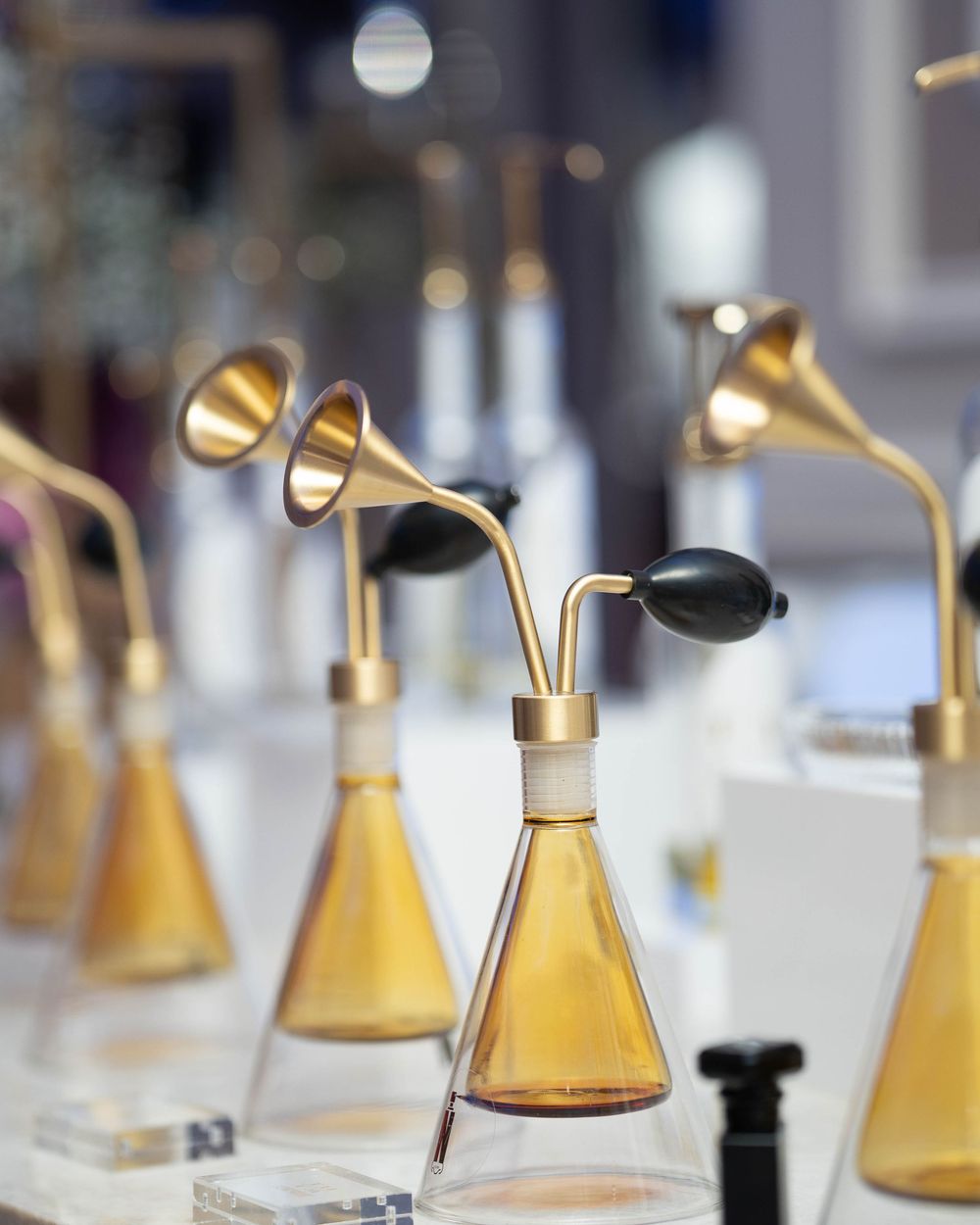 Row of sleek gold and black desk lamps with adjustable arms arranged in a modern retail display setting.