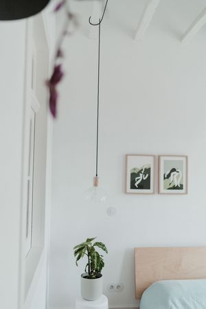 Minimalist bedroom interior with hanging pendant light, by a Portugal Wedding Photographer