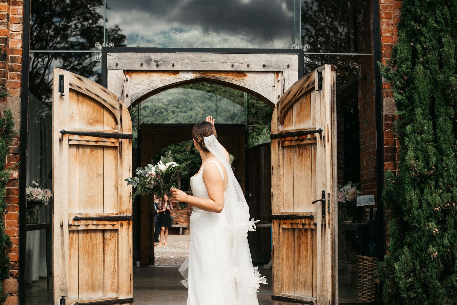 A black and white wedding reception scene inside a rustic venue with exposed brick walls and decorative lighting.