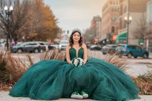Emerald green ballgown with sweetheart neckline photographed in urban fall setting.
