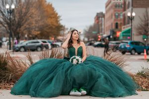 Emerald formal gown with full tulle skirt photographed on city street during autumn.