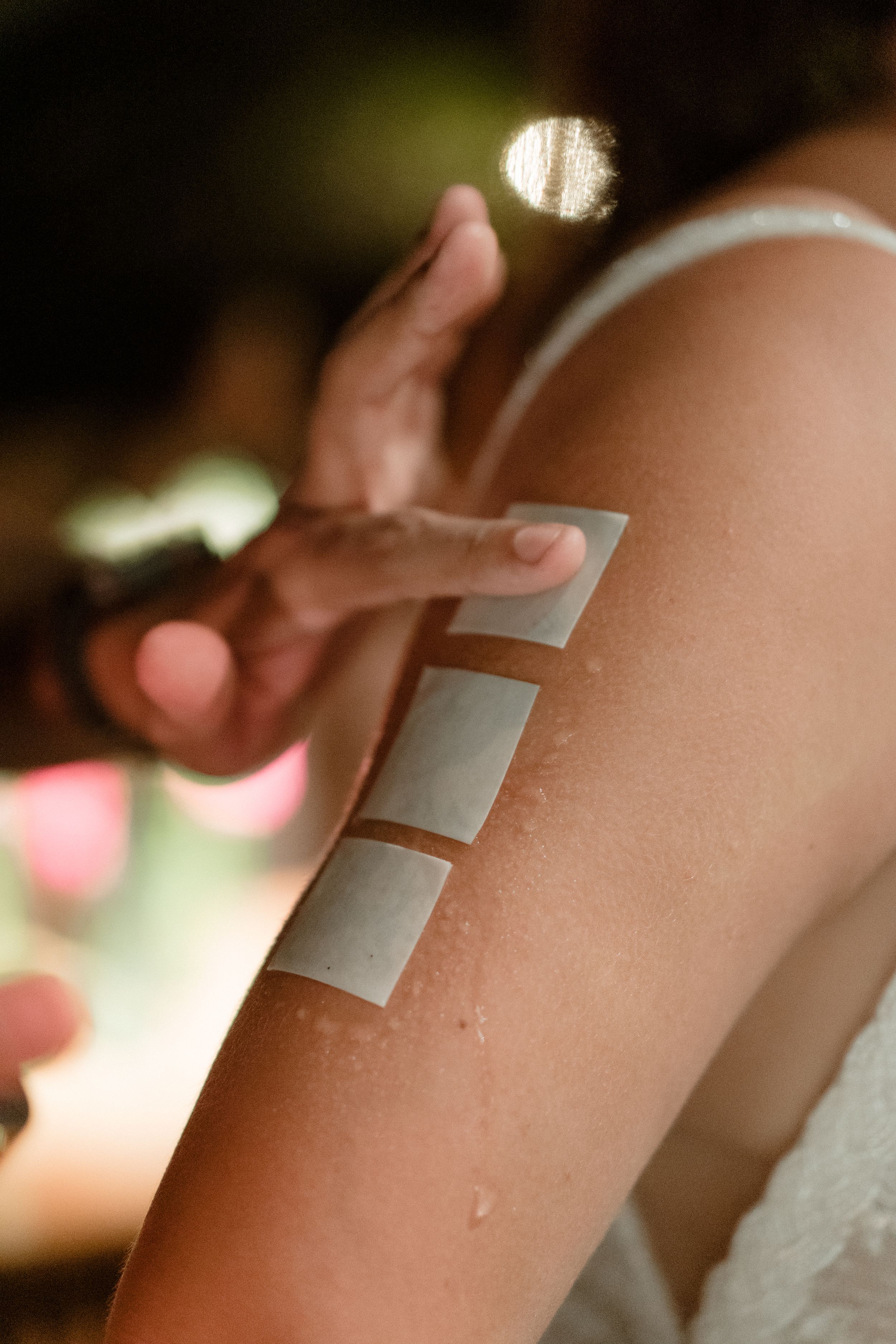 Small bandages being applied sequentially to an arm creating a first aid treatment progression.