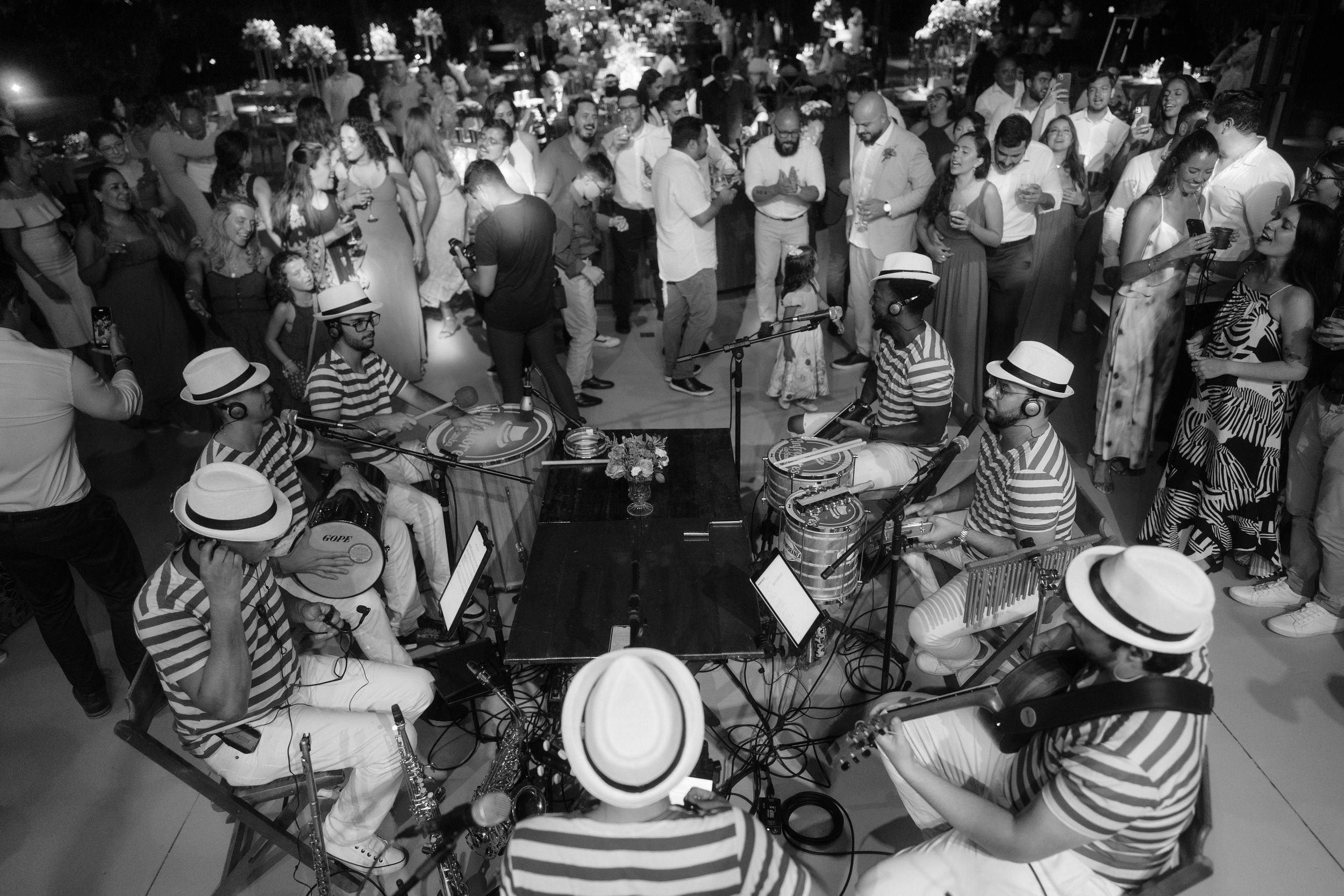 Large group of party guests wearing striped shirts and hats enjoying a celebration.