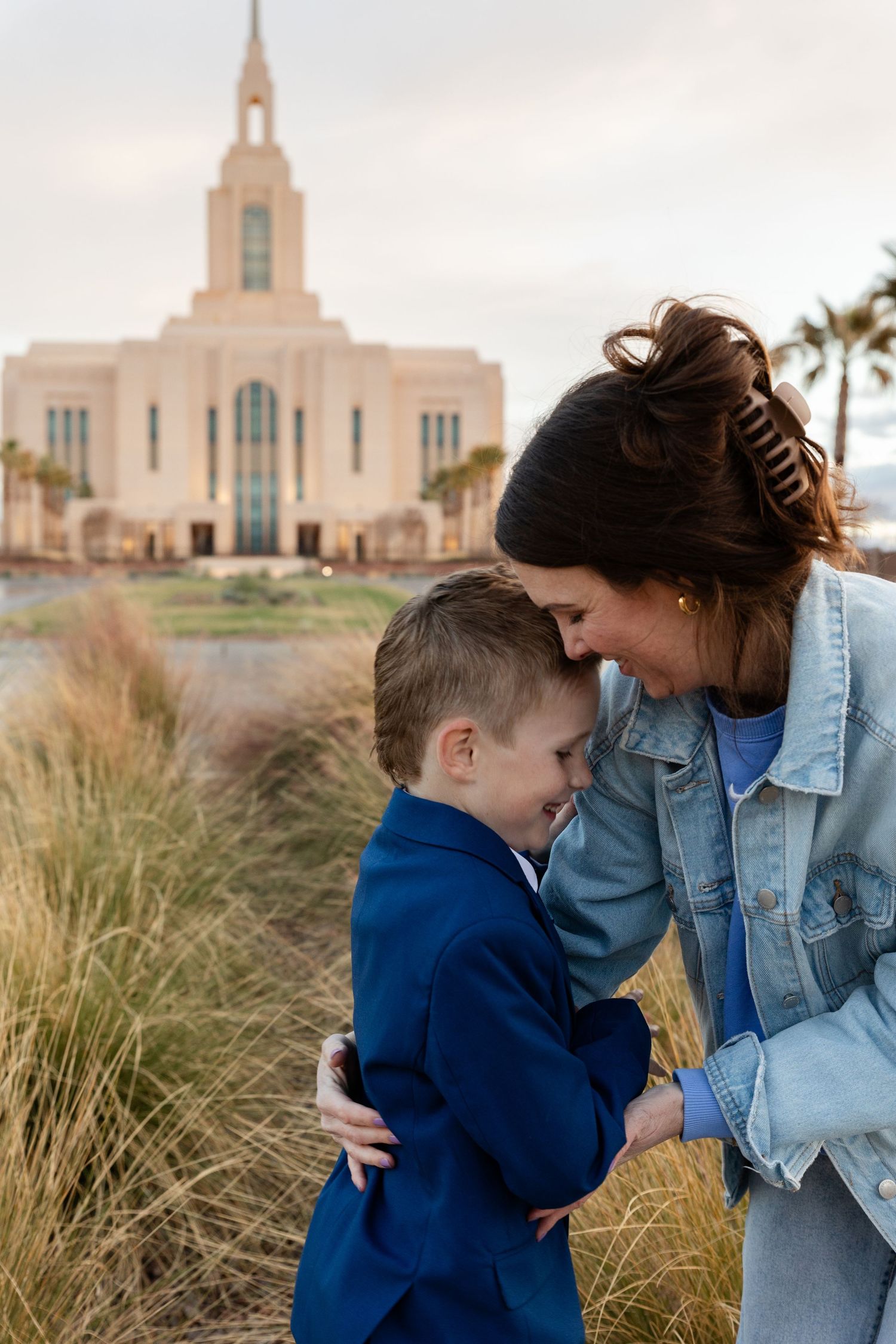 mom and son forehead to forehead laughing with the temple in the background