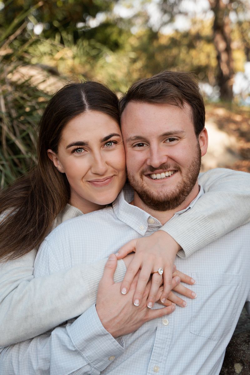 newly engaged couple hugging and cuddling during a proposal photoshoot in Sydney in a park
