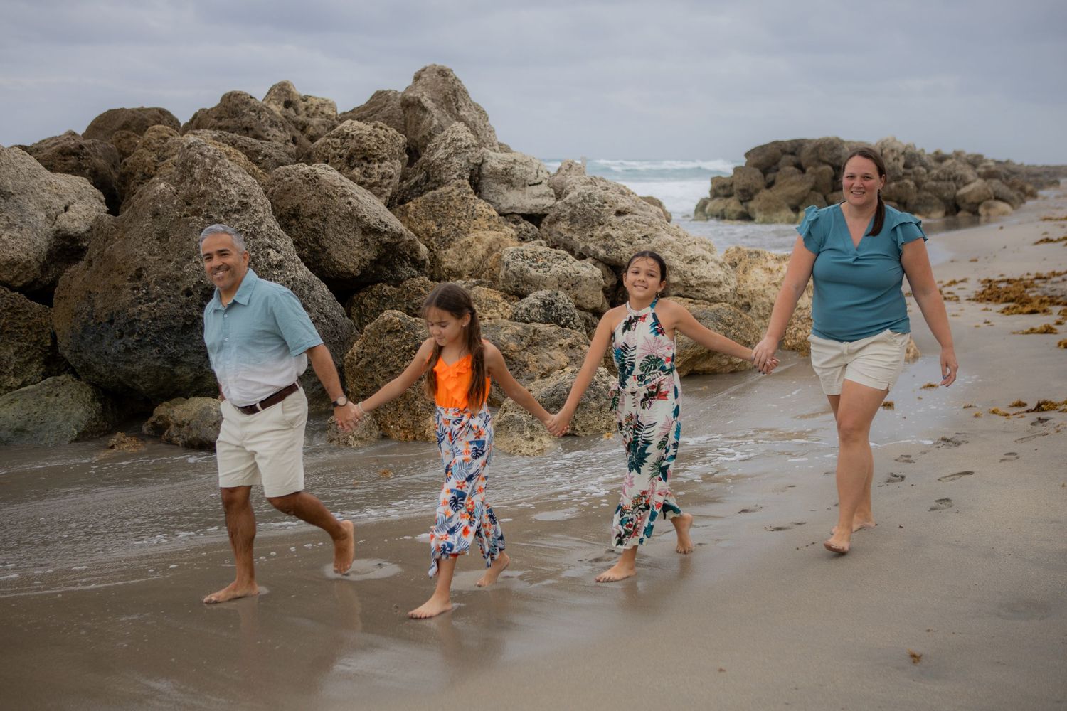 Family photoshoot picture in Deerfield Beach Florida, with giant rocks, taken by Wanderlust Studios