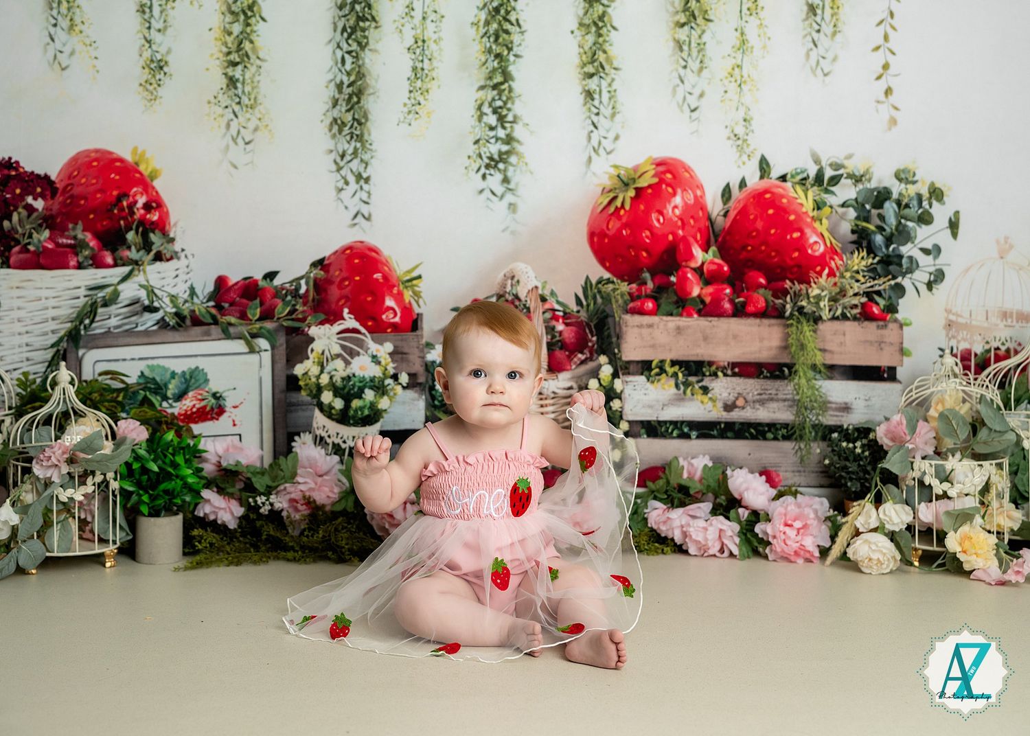 Valentine's Day themed portrait setup with oversized red hearts, pink flowers, and cascading greenery decorations.