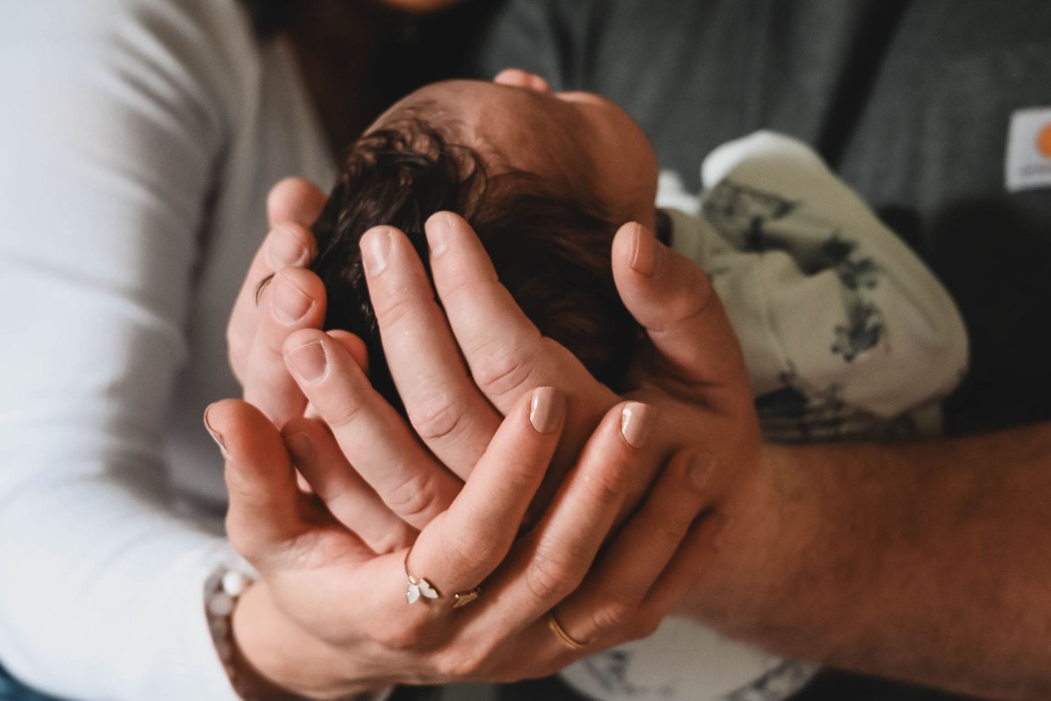 Mom and Dad's hands holding baby boy in a newborn session in Troy, NY