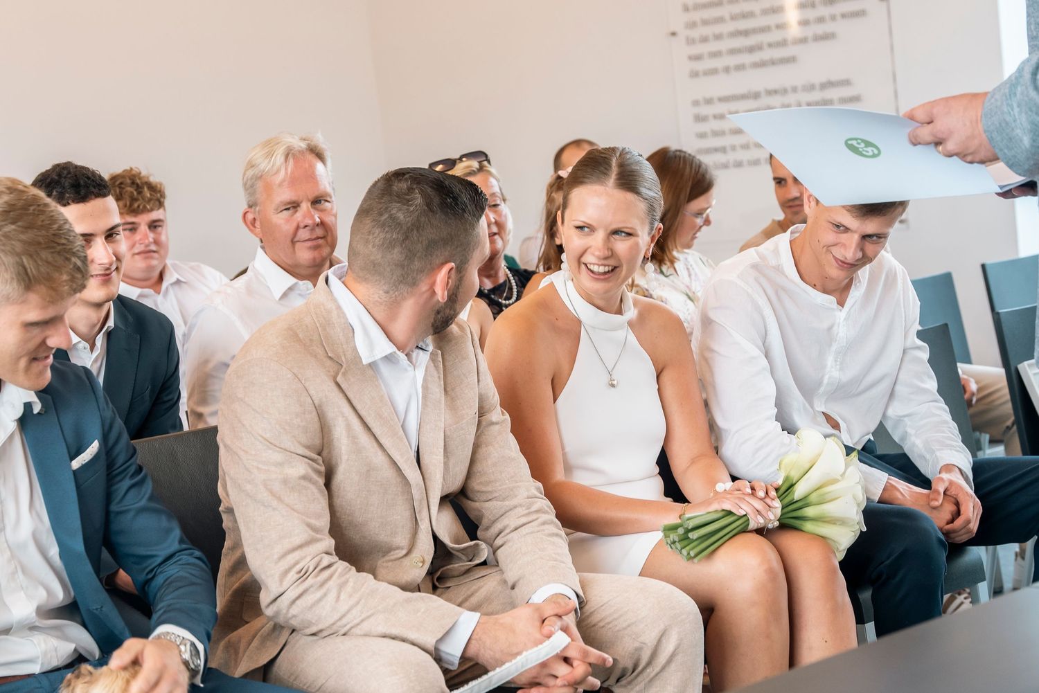 Wedding guests sitting and laughing together at a ceremony.