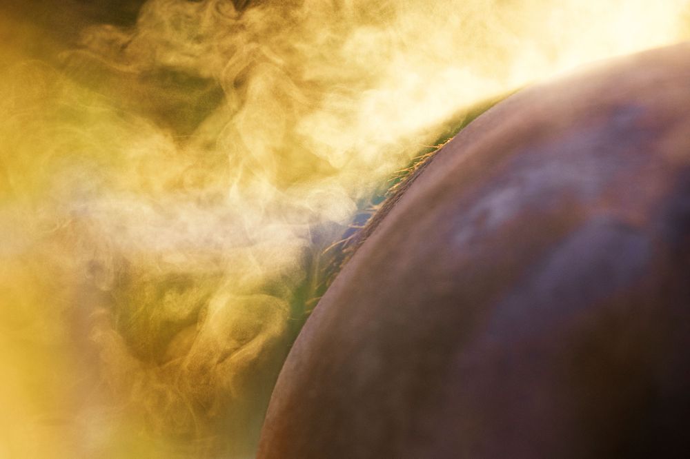Dramatic celestial scene with glowing yellow clouds and dark curved planetary surface.