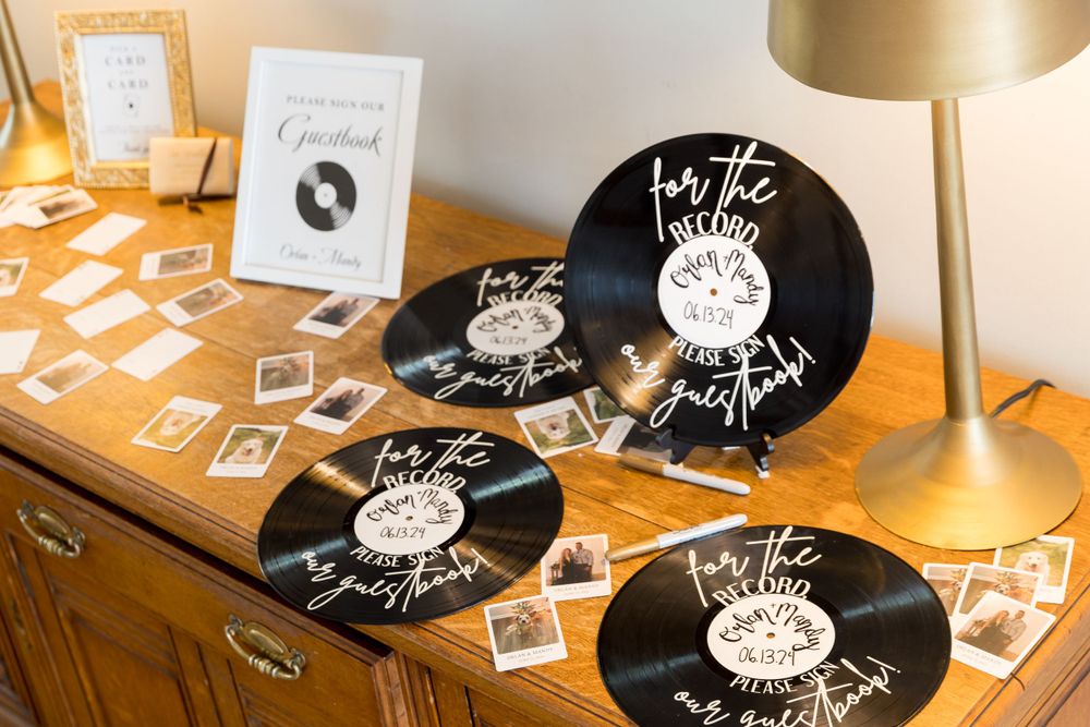 Decorative vinyl records and photographs displayed on wooden table as wedding reception decor.