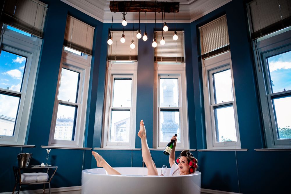 Panoramic view of a modern blue-walled room with windows and hanging light fixtures.