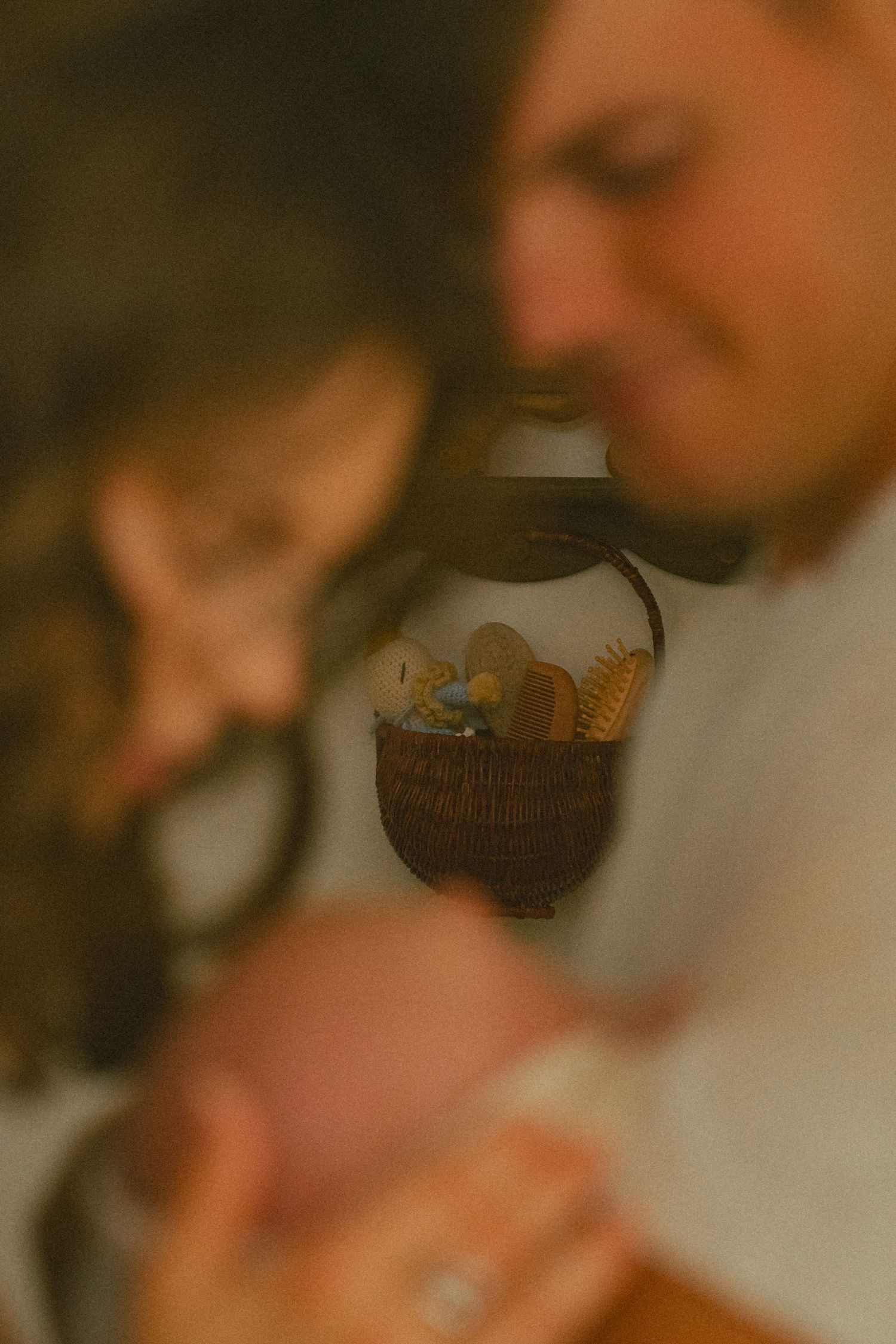 Soft focus close-up of family moment with decorative jar in background.