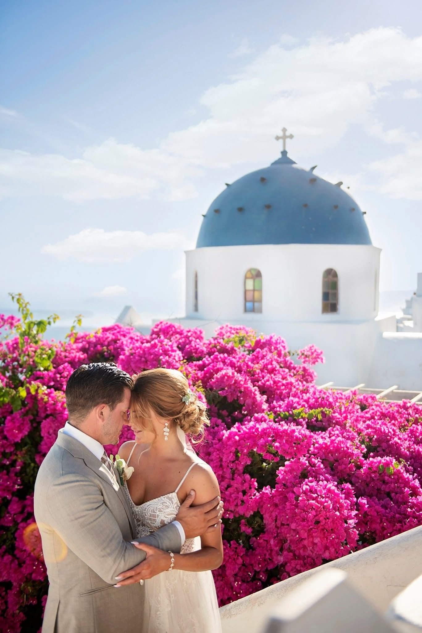 A stunning beach wedding ceremony setup with white chairs, flower arrangements, and string lights by the ocean.