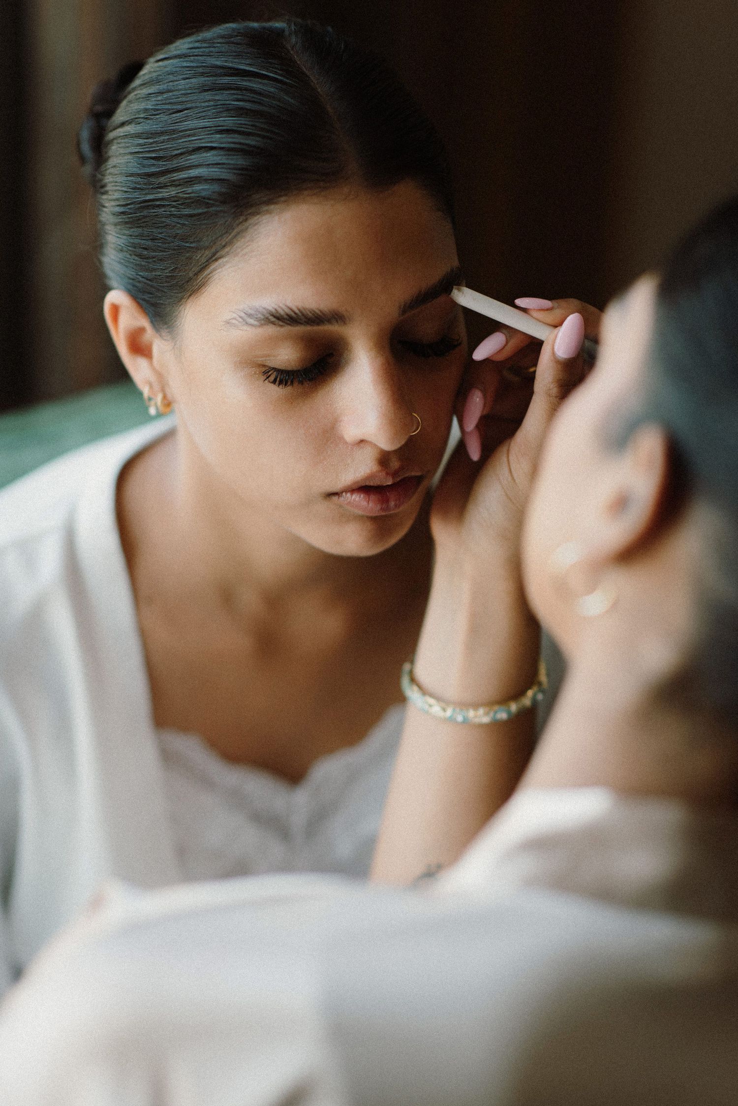 Close-up shot of someone getting their makeup professionally applied before a special event.