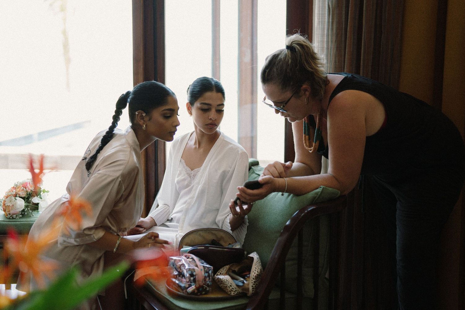 Group sits together near window in relaxed setting with bright lighting.