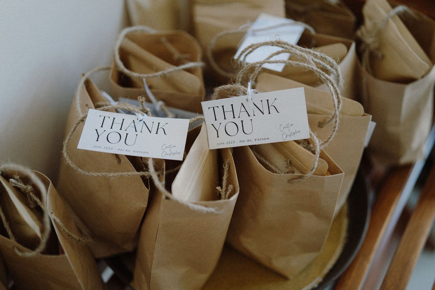 Brown paper gift bags with thank you tags arranged in a row.
