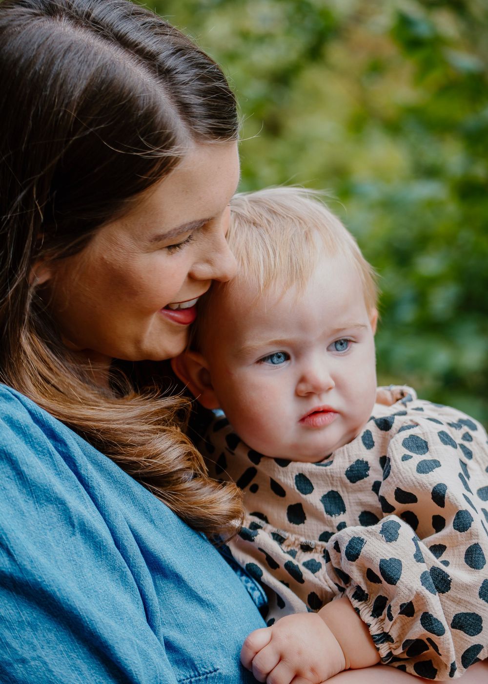 Family Photoshoot - Tender moment shared between parent and child wearing a polka dot outfit in a natural setting.