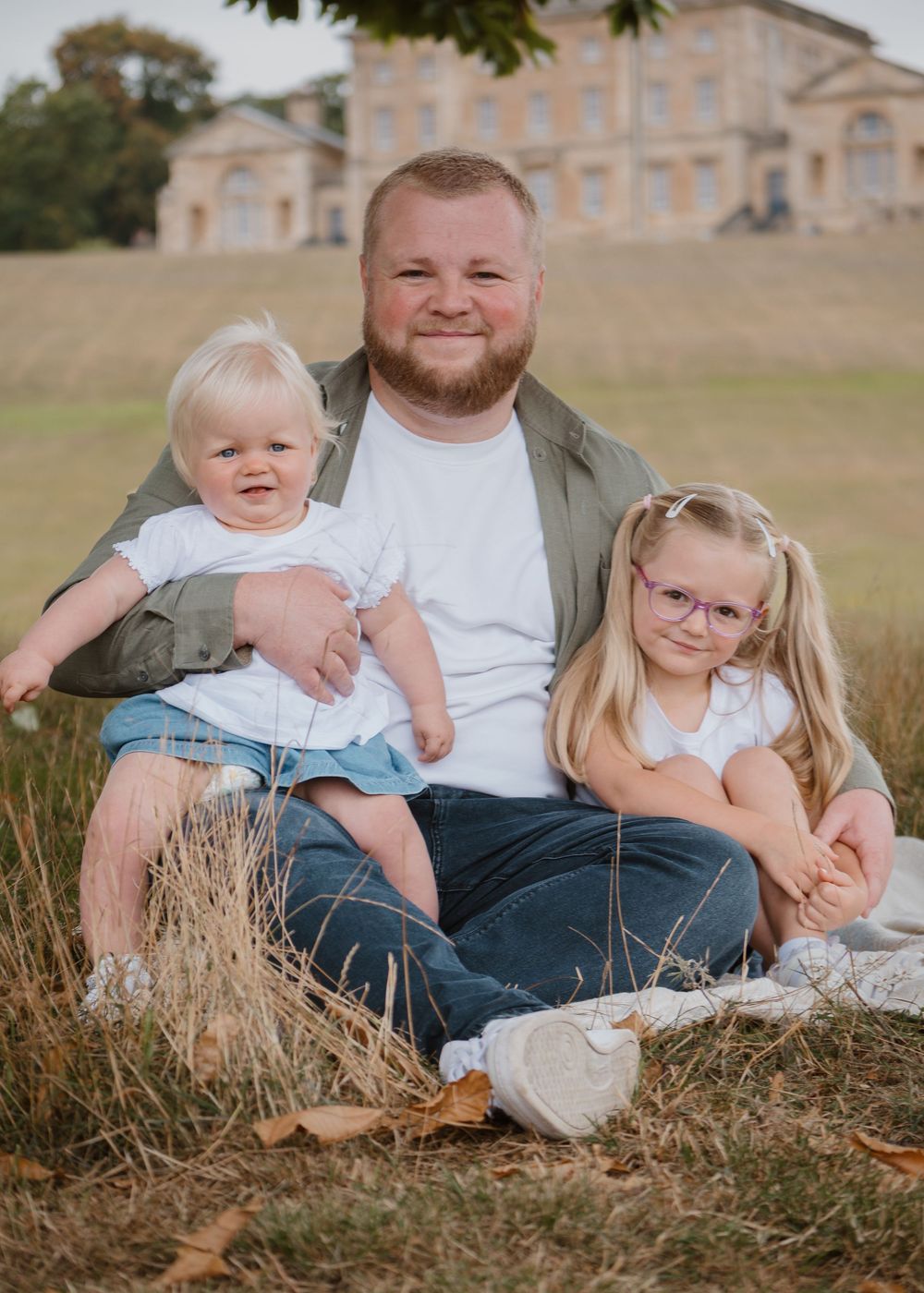 Family Photoshoot - Cusworth Hall - Family sitting together on grass with casual poses and natural expressions.