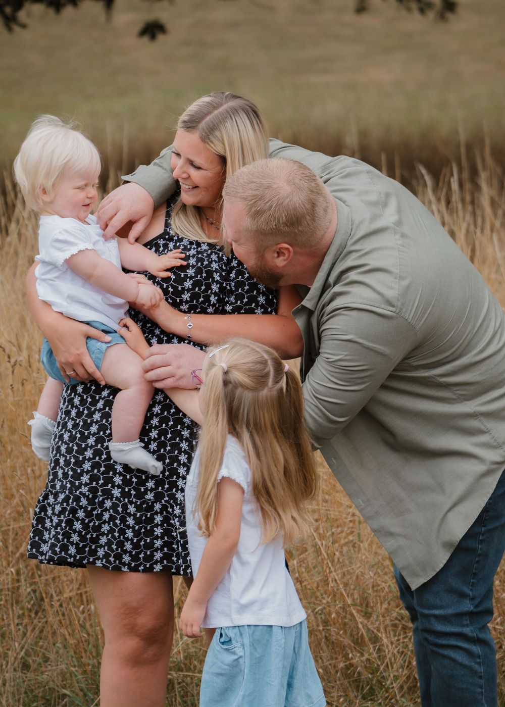 Family Photoshoot - Cusworth Hall - Family plays and interacts together in a golden field during sunset.
