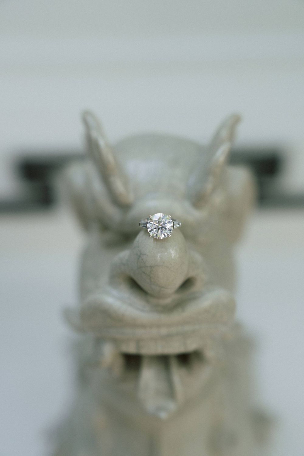 A series of close-up shots showing an engagement ring on a white ceramic surface.