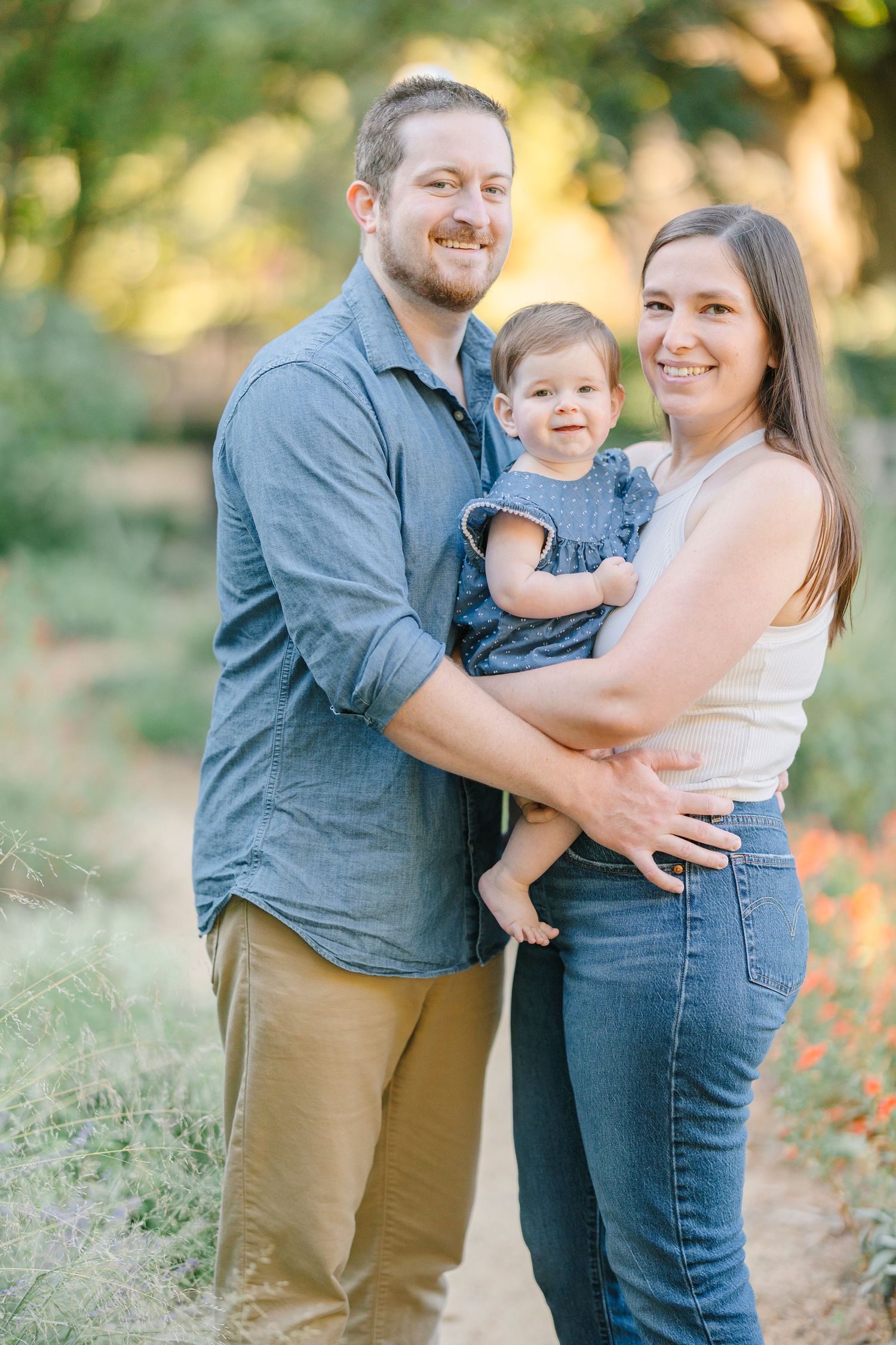 A family enjoys a tender moment together outdoors during a golden hour photoshoot in nature.