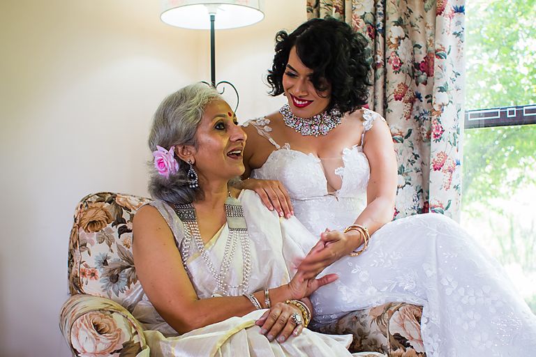 Woman in a white wedding dress shares tender moments on a floral couch in five sequential shots.
