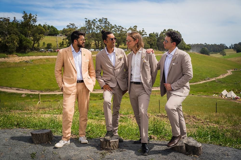 A multiframe photo collage showing groomsmen in light colored suits posing outdoors at a beautiful countryside venue.