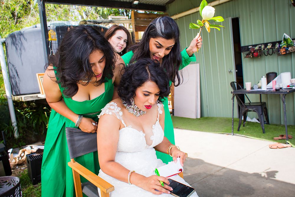Women in emerald green dresses gather together during an outdoor celebration event.