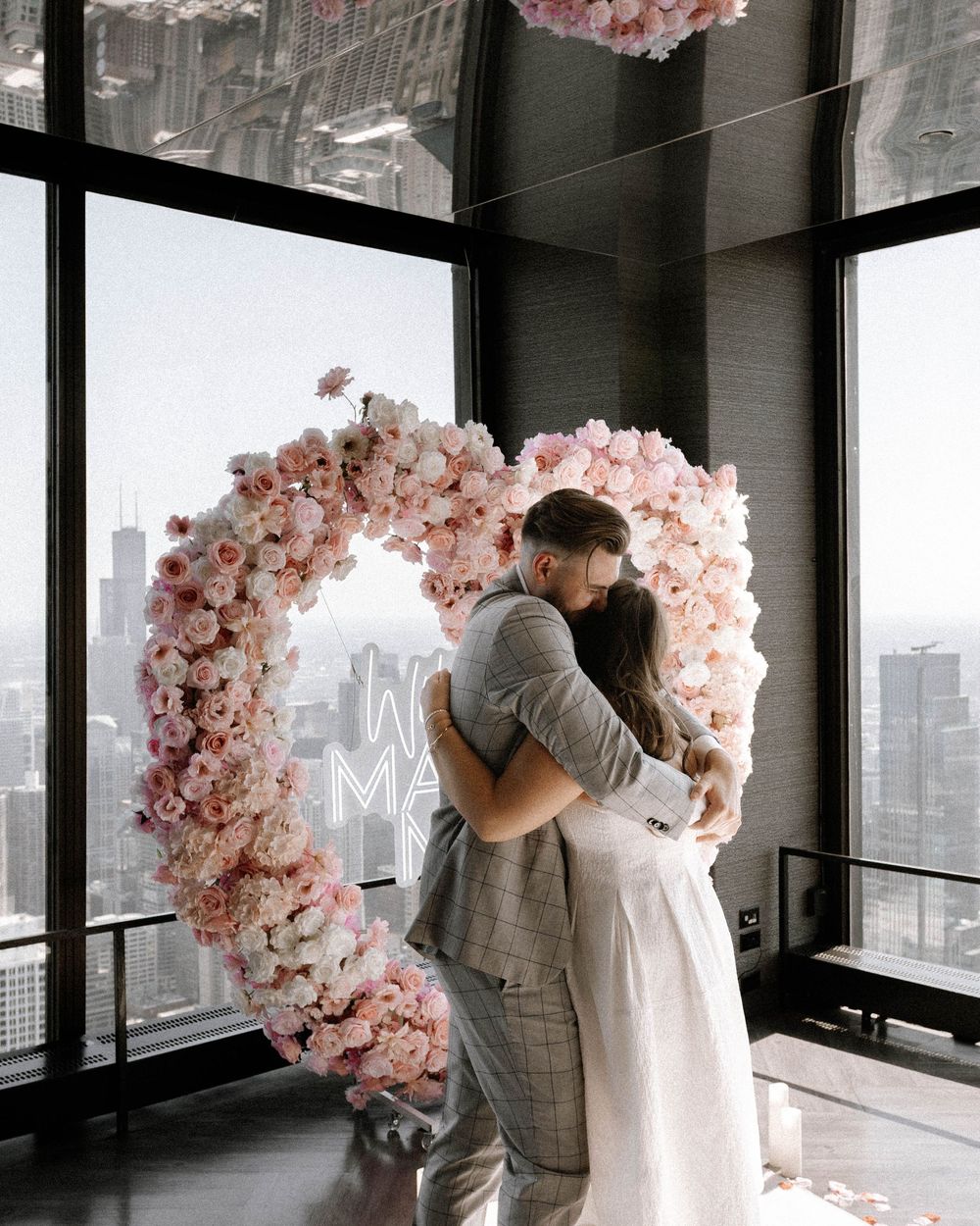 A romantic wedding moment captured through a series of photos with pink cherry blossom arches in a modern city venue.