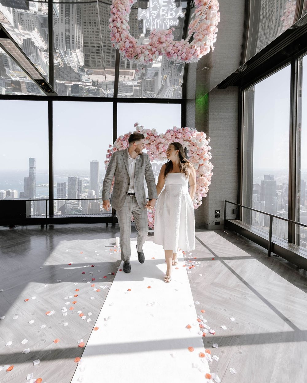A series of white wedding dress fittings in a bright modern space with floor to ceiling windows and pink cherry blossoms.