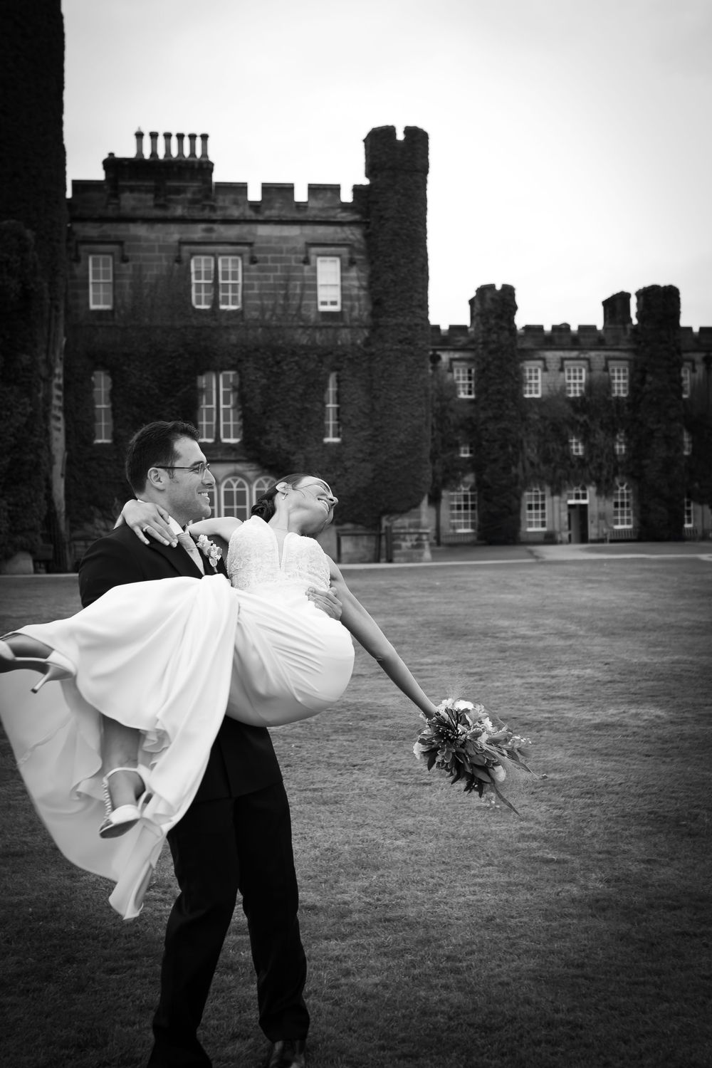 A romantic black and white sequence shows a groom dipping his bride in an elegant dance pose on a grassy lawn by a mansion.