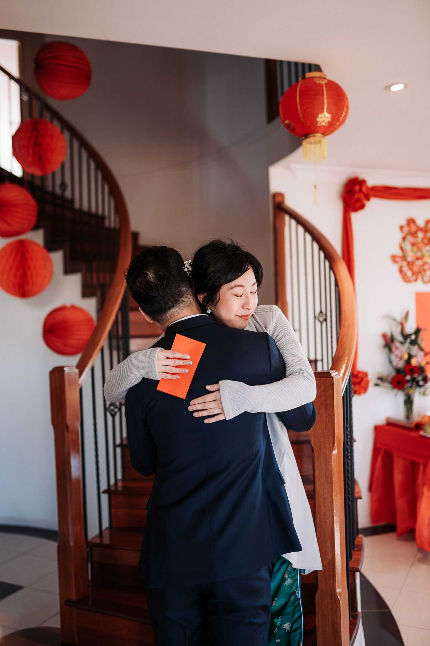 Traditional greeting ceremony in home decorated with red lanterns and Chinese New Year decorations.