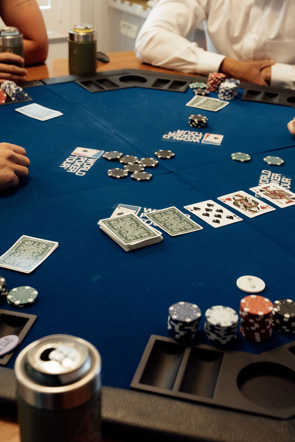 Playing cards and poker chips scattered across a blue felt table during a casino game.